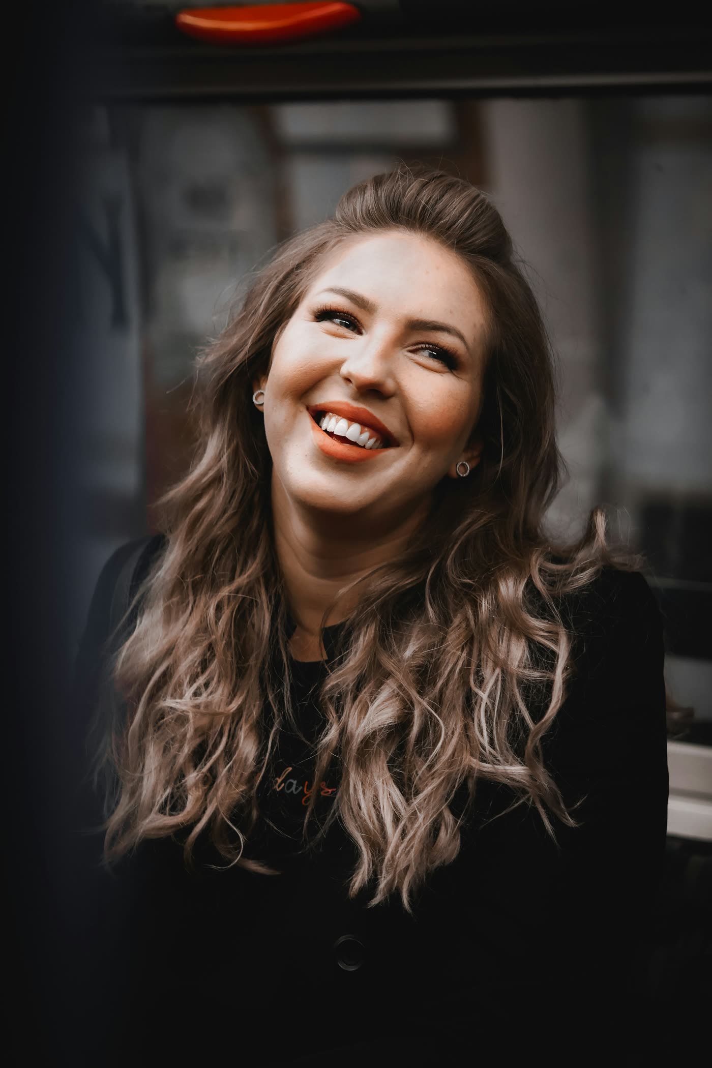 Retrato de Helena Duarte, psicóloga, sorrindo, com cabelos longos e ondulados